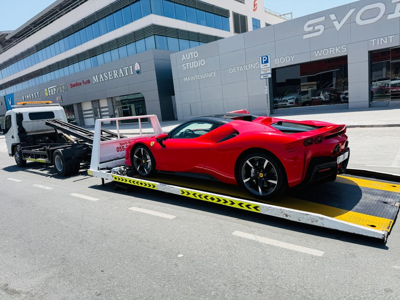 Full down recovery Dubai - Ferrari loaded on fully-lowered flatbed recovery truck