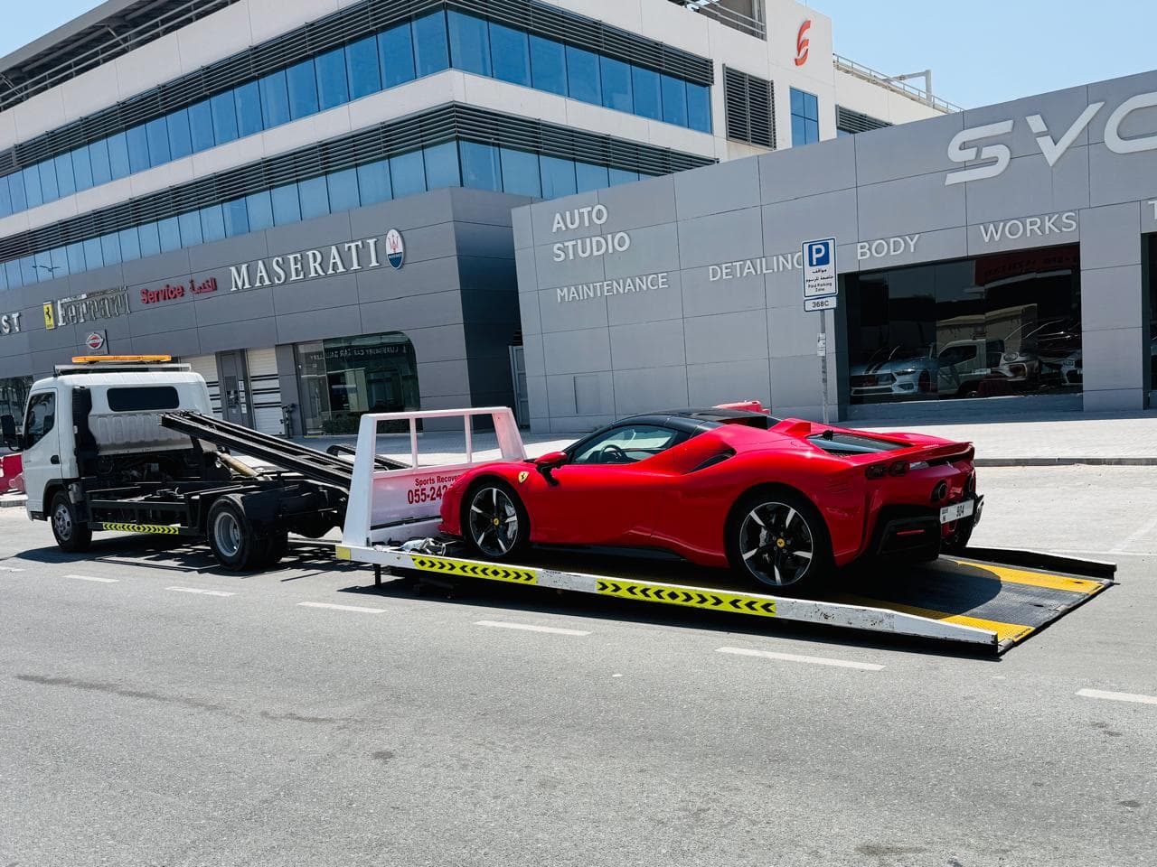 Luxury car recovery Dubai - Ferrari on flatbed at Dubai auto studio