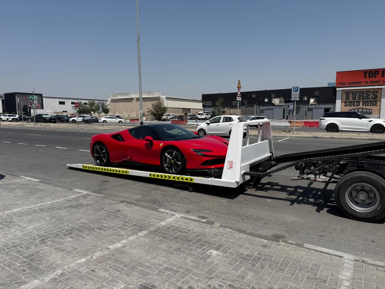 Ferrari SF90 loaded on a flatbed recovery truck in Dubai